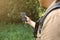 Tourist with smartphone and battery charger is looking for the way in summer forest. Guy with powerbank is lost in the nature.