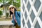 Tourist smiling and showing herself behind wall