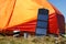 Tourist solar panel on orange tent in outdoor. Camping equipment, alternative source energy