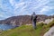 Tourist standing at Slieve League Cliffs which are among the highest sea cliffs in Europe rising 1972 feet above the