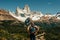 tourist stands on the background of the mountains of Fitz Roy in Argentina