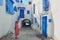 Tourist stands in the courtyard with blue windows and doors with Arabic ornaments. Texture of Islamic symbols in Sidi Bou said,