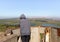 A tourist  stands in the remnant of a concrete trench at a former defensive post on Mount Bental, looking at the surroundings in