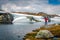 Tourist stands on a rock among the lake. Great summer view on the field near the famous Aurlandsvegen - Mountain road Bjorgavegen