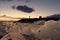 A tourist stands silhouetted against the evening sky above a field of icebergs