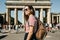 A tourist or a student with a backpack near the Brandenburg Gate in Berlin in Germany, looks at the sights.