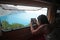 A tourist takes a picture from inside her camper van of the view from above of the beach of Porto