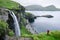 A tourist takes pictures of the Skardsafossur waterfall, Faroe Islands