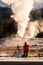 Tourist taking the explosion of old Faithful, Yellowstone in morning