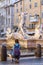 Tourist taking a photo of 16th century Fountain of Neptune located in Piazza Navona, Rome, Italy