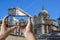 Tourist taking photo of ancient ruins in a summer day in Roman Forum in Rome, Italy. Man holding phone and taking picture arch of