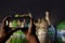 Tourist taking photo of canal of Bruges, tower and historic buildings at night, Bruges, Belgium. Man holding phone and taking
