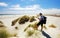 Tourist taking photo of Farewell spit sand dunes
