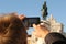 Tourist taking pictures of King Jose I equestrian statue in Lisbon