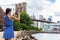 Tourist taking travel picture with phone of Brooklyn bridge, New York