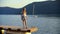 Tourist teen girl on sea pier looking around on green highlands and yacht background. Happy traveling girl admiring