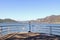 Tourist telescope on the alpine lake of Iseo, it is pointed the lake and the Alps. Sunny day with a blue sky and a bit of wind