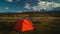 Tourist tent in camp among alpine meadows in the mountains at sunset.