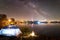 Tourist tent and campfire on lake shore at night