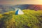 Tourist tent on green meadow at sunrise. Camping background.