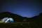 The tourist tent is illuminated by light. Starry sky. Tourism and active recreation. Overnight, camping in the Carpathian