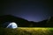 The tourist tent is illuminated by light. Starry sky. Tourism and active recreation. Overnight, camping in the Carpathian