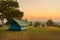 Tourist tent on among meadow in the sunset overlooking mountains. outdoors camping