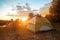 Tourist tents at riverbank in forest in summer morning