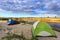 Tourist tents at riverbank in forest in summer morning