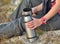 Tourist with a thermos. woman pours tea on the nature