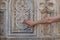 Tourist touching ancient carved wall