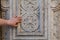 Tourist touching ancient carved wall