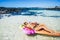 Tourist travel woman relax and enjoying the sun and beach laying on a colorful lilo in transparent tropical ocean water during