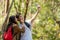 Tourist and traveler asian couple backpack enjoy happy take a photo selfie in the jungle forest nature park . Traveler going campi