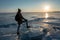 Tourist traveler with a backpack watching the sunset on the snowy ice of lake Baikal. Concept of freedom and travel