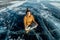 Tourist traveler meditates sitting in Lotus position on the ice of lake Baikal