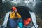 Tourist traveler ralaxing in camp tent in foggy rain forest, closeup happy hiker woman enjoy mist nature trip, green trekking