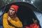 Tourist traveler ralaxing in camp tent in froggy rain forest, closeup lonely hiker woman enjoy mist nature trip, green trekking