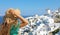 Tourist traveling in Santorini, Oia island in Greece, Europe travel summer vacation woman relaxing at view windmills. Holiday girl