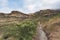 Tourist trekking on marked trail in the Golden Gate Highlands National Park, South Africa. Scenic table mountains, canyons and cli