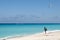 A tourist at a tropical beach photographs parasailing on the Sea in Mexico