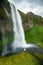 Tourist under the waterfall in Iceland, Adventure photo, edit sp