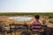 Tourist waits for wildlife at the Moringa waterhole near Halali, Etosha, Namibia