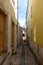 A tourist walking down a narrow alleyway in the old town of Lisbon, Portugal