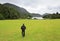 Tourist walking on lawn to the Muckross Lake.