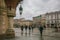 Tourist walking in the market square of Krakow on rainy day in Poland