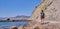 A tourist walks along the path of the rocky coast of Cape Meganom on the Black Sea, Crimea peninsula