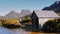 Tourist walks past the boat shed on the shore of dove lake