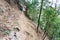 tourist walks on path through mudslide on mountain