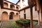 Tourist watching window inside historical courtyard with arch in traditional house of Andalusia, Spain